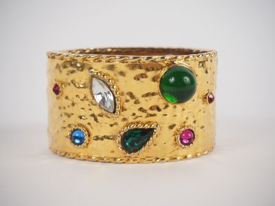 a close up of a gold ring with multi colored stones