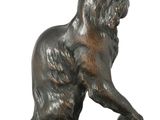 bronze statue of a bear on a rock on a white background