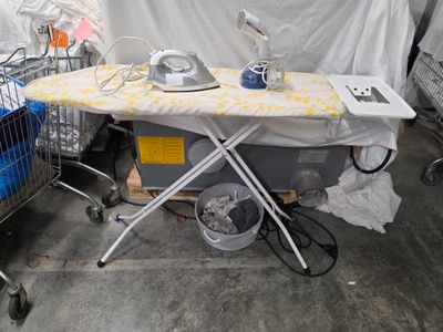 une table à repasser et un chariot dans une pièce