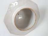 a white vase with a brown rim sitting on a table