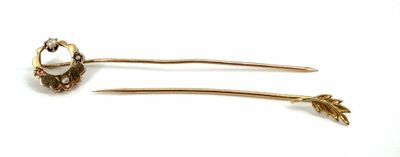 pair of gold tone hair pins with white stones on them
