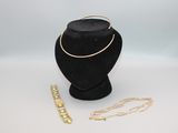 un collier, un bracelet et un porte-bracelet posés sur une table