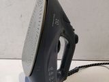 an electric iron sitting on top of a counter next to a cord