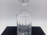 un gros plan d'une bouteille en verre transparent posée sur une surface noire