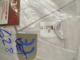 a white shirt with blue writing on it next to a pair of scissors