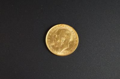gros plan d'une pièce d'or sur une surface noire
