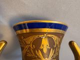 a blue and gold vase sitting on a table