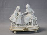 a figurine of two women and a child on a table