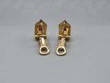 a pair of gold tone earrings with a red stone