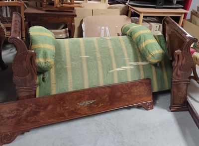 a bed that has a green and yellow striped blanket on it