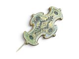 une broche dorée et bleue fixée à un bâtonnet
