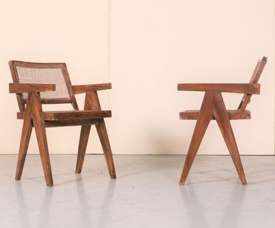 deux chaises en bois placées l'une à côté de l'autre devant un mur