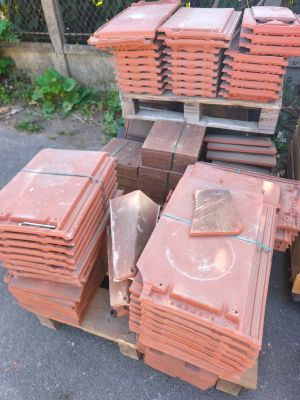 de nombreuses piles de briques rouges sur une palette