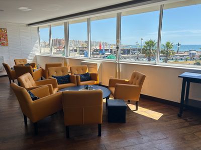 de nombreuses chaises et tables dans une pièce avec vue sur l'océan