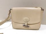 beige leather purse with a metal clasp on a white surface