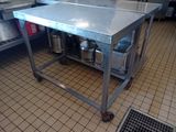 a stainless steel table in the middle of a kitchen