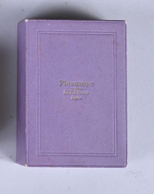 purple book with gold lettering on it sitting on a white surface