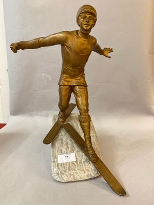bronze statue of a man on skis on a marble base