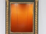 an image of a green and gold mirror on a white wall