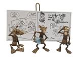 three figurines of three monkeys with a book and a sign