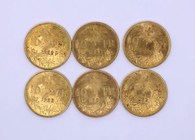 six gold coins are arranged in a row on a white surface