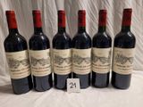 six bouteilles de vin rouge sont alignées sur une table