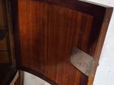 a small wooden cabinet with a marble top in a room