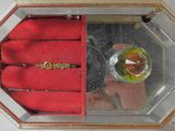 a small glass box with a ring inside of it