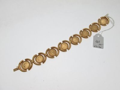 un bracelet en or orné d'une pièce et d'une étiquette