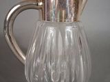 a glass pitcher with a silver lid on a table