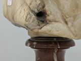 a stone head on a wooden base on a table