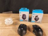deux souris sans fil noires posées sur une table en bois