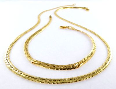 a gold plated necklace and bracelet set on a white background