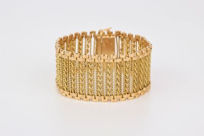 gros plan d'un bracelet en or sur fond blanc