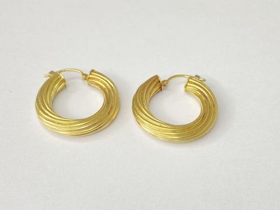 a pair of gold hoop earrings on a white background