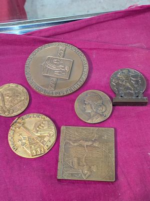 some of the coins are sitting on a pink cloth