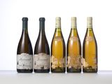 four bottles of wine are lined up on a table