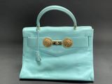 a mint green leather handbag with gold hardware