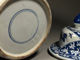 a blue and white vase sitting next to a blue and white cup