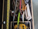 une caisse en bois posée par terre, contenant des outils