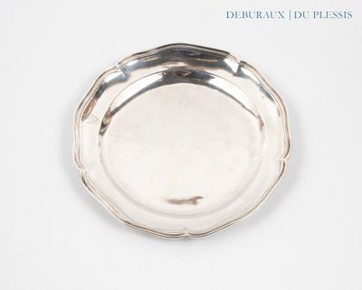une assiette en argent posée sur une surface blanche avec un fond bleu
