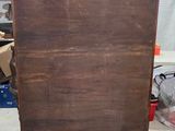 a wooden cabinet with a drawer on top of it