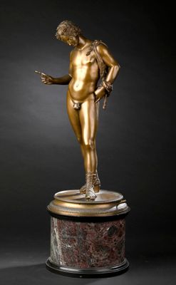 une statue en bronze représentant un homme tenant une balle, posée sur un socle en marbre