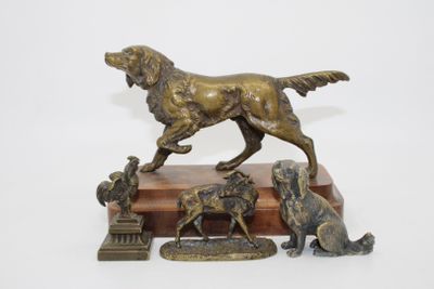 statue en bronze représentant un chien et quatre autres chiens, posée sur un socle en bois