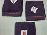 Trois serviettes violettes portant le nom « bensmon » sont posées sur une table