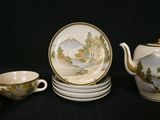 five cups and a teapot on a black table