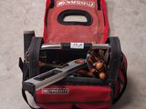 a tool bag with tools inside of it on the floor