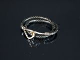 une image représentant un bracelet muni d'un fermoir, posé sur une surface noire