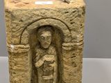 statue représentant une personne tenant un couteau, sculptée dans un bloc de pierre
