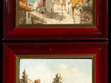 two framed paintings of a village scene with a river and buildings
